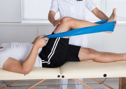 Physiotherapist Helping Patient While Exercising