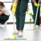 Close-up of person with yellow gloves cleaning the floor by using mop
